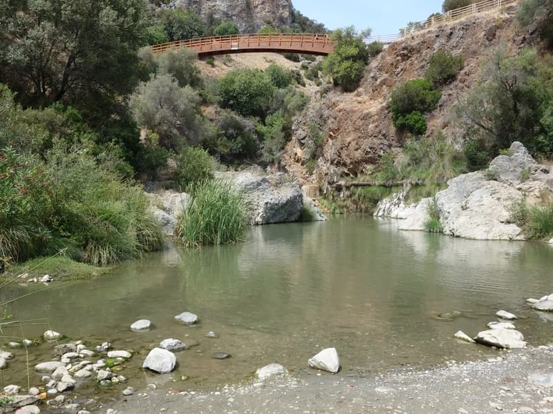 Wooden bridge and clear pool on the Guadalmina river gorge near Benahavís